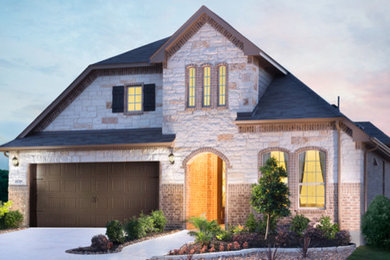 Example of a large trendy beige one-story brick exterior home design in Austin