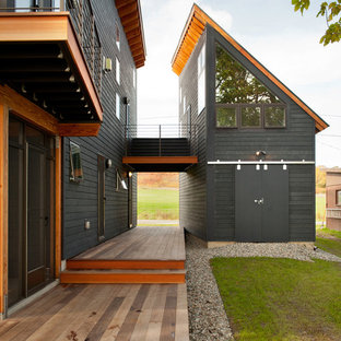 Inspiration för ett mellanstort funkis grått hus, med två våningar, pulpettak och tak i metall