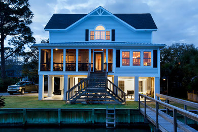 Inspiration for a large coastal three-story concrete exterior home remodel in Charleston with a hip roof