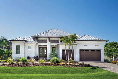 Example of a beach style gray house exterior design in Other with a hip roof and a metal roof