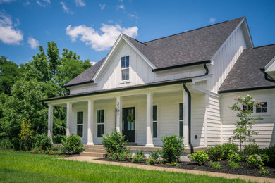 Diseño de fachada de casa blanca de estilo de casa de campo de dos plantas con revestimientos combinados y tejado de teja de madera