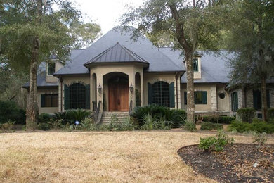 Example of a mid-sized classic beige one-story stucco exterior home design in Other with a hip roof