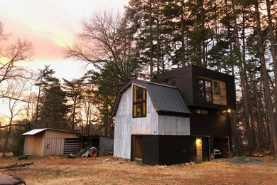 Ejemplo de fachada de casa negra contemporánea pequeña de dos plantas con revestimiento de madera, tejado a doble faldón y tejado de metal