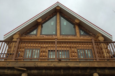 На фото: двухэтажный, деревянный, коричневый дом в скандинавском стиле с двускатной крышей с