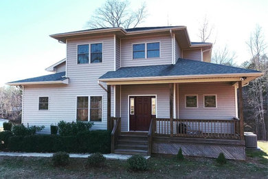 Example of a mid-sized transitional white two-story vinyl house exterior design in Charlotte with a hip roof and a shingle roof