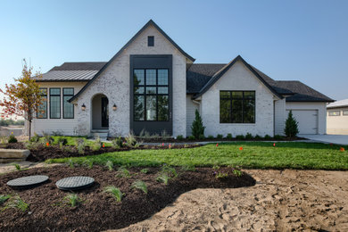 Inspiration for a country white one-story brick exterior home remodel in Omaha with a metal roof