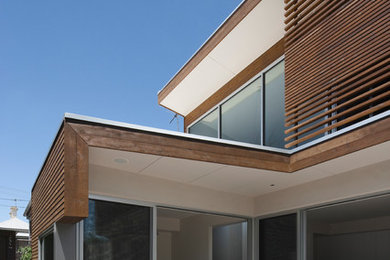 Idée de décoration pour une façade de maison design en bois de taille moyenne et à un étage.