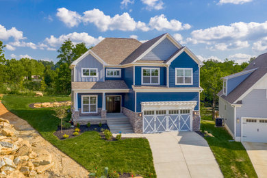 Ejemplo de fachada de casa azul de estilo americano de tamaño medio de dos plantas con revestimiento de vinilo y tejado de teja de madera
