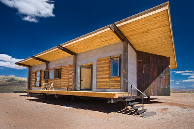 Идея дизайна: одноэтажный, серый частный загородный дом среднего размера в стиле фьюжн с комбинированной облицовкой, плоской крышей и металлической крышей
