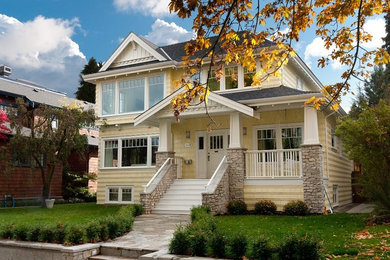 Inspiration for a timeless yellow two-story exterior home remodel in Vancouver