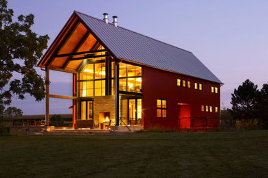Example of a farmhouse red gable roof design in Milwaukee