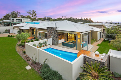 Large minimalist one-story brick exterior home photo in Brisbane with a hip roof