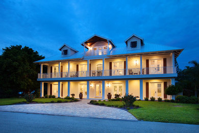 Example of a large beach style white three-story wood exterior home design in Tampa