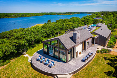 Idées déco pour une grande façade de maison grise bord de mer en bois de plain-pied avec un toit en shingle.