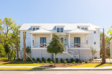 Example of a large cottage blue three-story wood house exterior design in Charleston with a metal roof and a hip roof