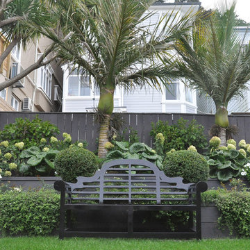 Tiered planting design with Nikau palms and Lutyens bench