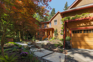 Diseño de fachada de casa marrón de estilo americano grande de dos plantas con revestimiento de madera y tejado a dos aguas