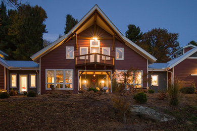 Idées déco pour une grande façade de maison rouge classique en bois à un étage avec un toit à quatre pans et un toit en métal.