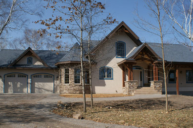 Modelo de fachada de casa beige rústica de tamaño medio de dos plantas con revestimiento de estuco, tejado a cuatro aguas y tejado de teja de madera