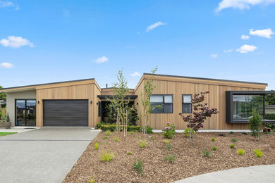 Ejemplo de fachada de casa multicolor minimalista grande de una planta con revestimiento de madera y tejado de metal