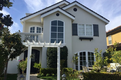 Inspiration for a mid-sized timeless gray two-story stucco gable roof remodel in Orange County