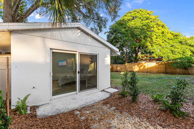 Small and white modern bungalow render tiny house in Tampa with a pitched roof and a shingle roof.