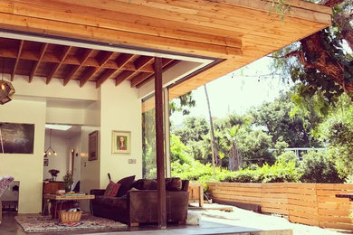 Inspiration for a small eclectic beige two-story glass exterior home remodel in Los Angeles with a mixed material roof