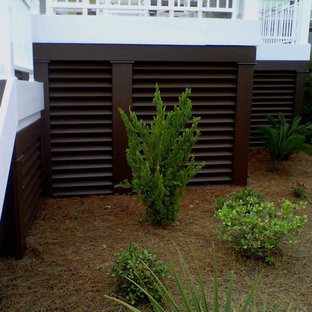 Foto de fachada amarilla, costera, de tres plantas, con revestimiento de aglomerado de cemento