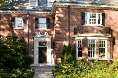 Example of a large classic red two-story brick exterior home design in Toronto