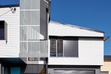 Diseño de fachada de casa blanca actual de tamaño medio de dos plantas con tejado de metal