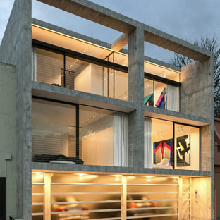 Photo of a mid-sized industrial three-storey concrete grey townhouse exterior in Melbourne with a flat roof and a mixed roof.