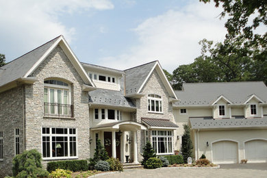 Modelo de fachada de casa beige clásica de tamaño medio de dos plantas con revestimientos combinados, tejado a dos aguas y tejado de teja de madera