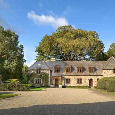 Example of a classic two-story stone exterior home design in New York