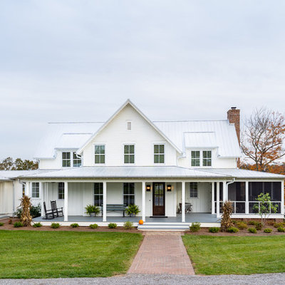 Large farmhouse white three-story concrete fiberboard exterior home idea in Other with a metal roof