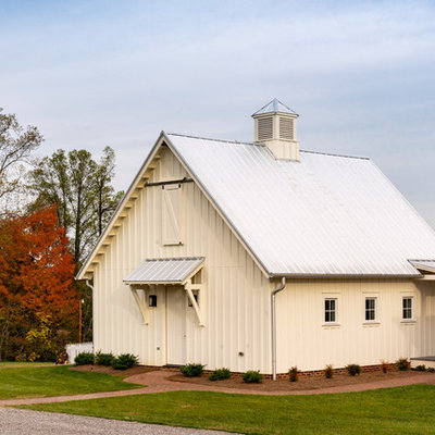 Large cottage white three-story concrete fiberboard exterior home photo in Other with a metal roof