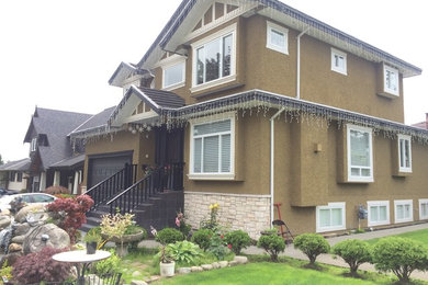 Inspiration for a large timeless brown two-story stucco exterior home remodel in Vancouver with a shingle roof
