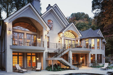 Large traditional gray two-story stucco gable roof idea in Atlanta