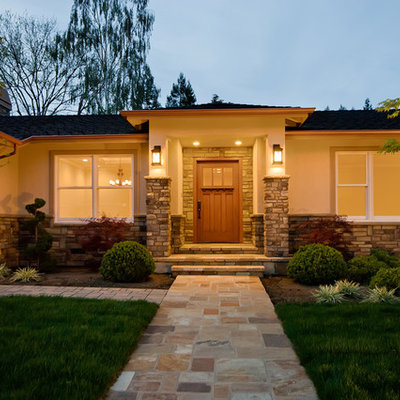 Large arts and crafts beige one-story stucco exterior home photo in San Francisco with a shingle roof
