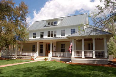 Exemple d'une façade de maison blanche chic en panneau de béton fibré de taille moyenne et à un étage avec un toit à deux pans et un toit en métal.