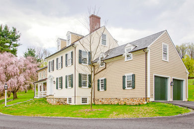 Imagen de fachada de casa multicolor de estilo de casa de campo de tres plantas con revestimiento de piedra y tejado a dos aguas