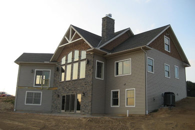 Foto de fachada de casa gris tradicional grande de dos plantas con revestimientos combinados, tejado a dos aguas y tejado de teja de madera