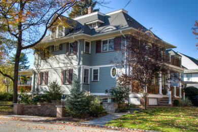 Inspiration for a mid-sized timeless green three-story wood house exterior remodel in New York with a hip roof and a shingle roof