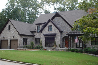 Imagen de fachada de casa gris clásica de dos plantas con revestimiento de piedra, tejado a dos aguas y tejado de teja de madera