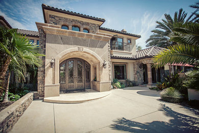 Example of a beige two-story stucco exterior home design in Other with a hip roof