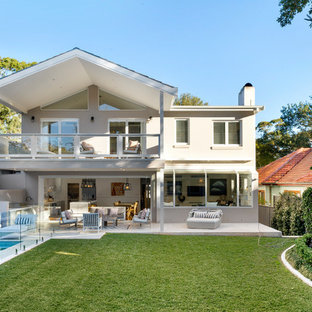 This is an example of a transitional one-storey concrete beige house exterior in Wollongong with a gable roof.