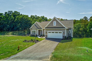 Example of a large transitional beige one-story mixed siding house exterior design with a clipped gable roof and a shingle roof