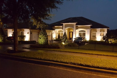 Mid-sized transitional white one-story stucco house exterior photo in Orlando with a clipped gable roof and a tile roof