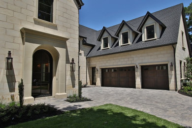 This is an example of a large and gey traditional two floor house exterior in Houston with stone cladding and a pitched roof.