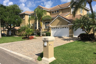 Inspiration for a large mediterranean beige two-story stucco exterior home remodel in Tampa with a tile roof