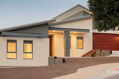 Imagen de fachada de casa gris actual grande a niveles con revestimientos combinados, tejado plano y tejado de metal